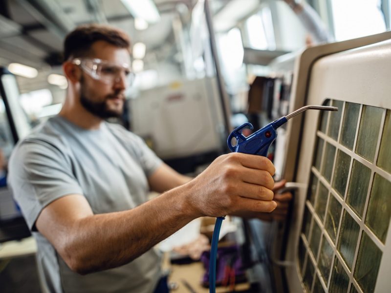 close-up-worker-operating-industrial-machine-factory